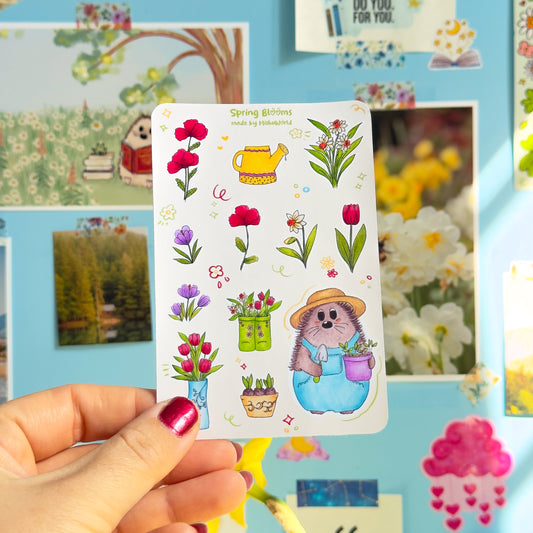 Sticker sheet with a hedgehog and floral design held by a hand against a colorful background.