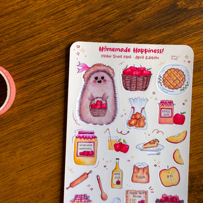 close up of the kawaii sticker sheet from the Mishu Snail Mail April Edition "Homemade Happiness", featuring Mishu the Hedgehog and hand-illustrated apple-themed designs on a wooden surface.
