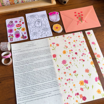 Floral stationery items including cards, envelopes, and stickers on a wooden surface.