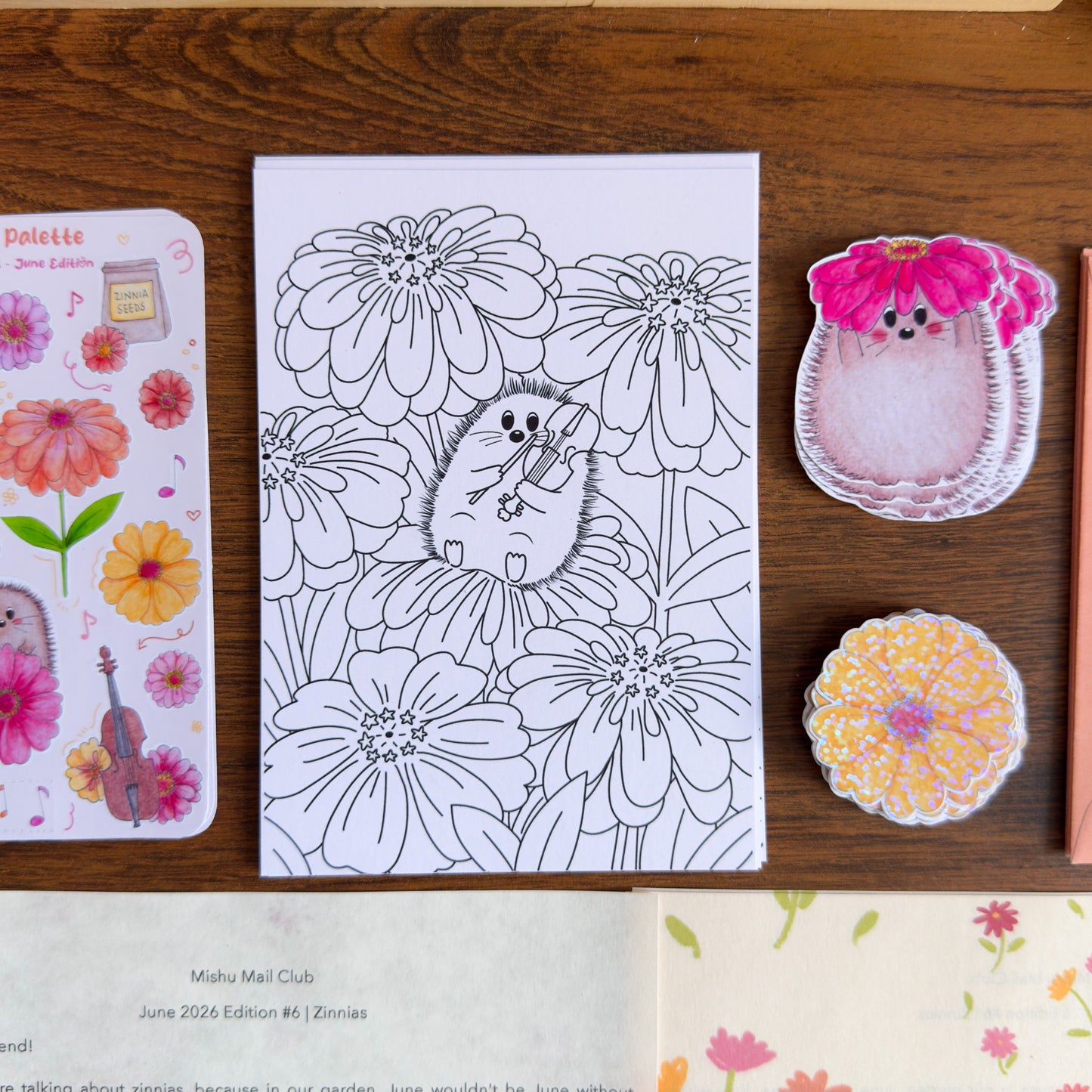 Coloring page with hedgehog and flower design on a wooden surface with decorative items.