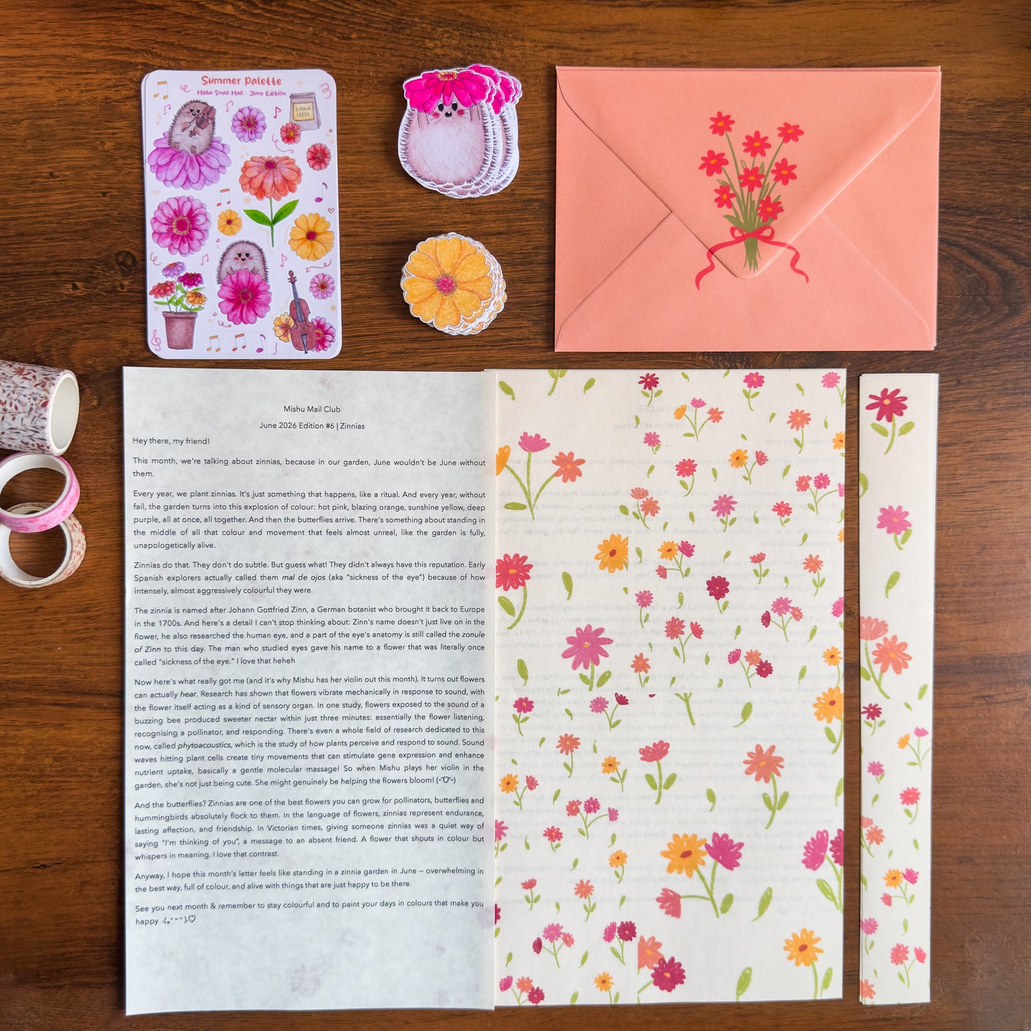 Floral stationery set with a letter, envelope, and stickers on a wooden surface